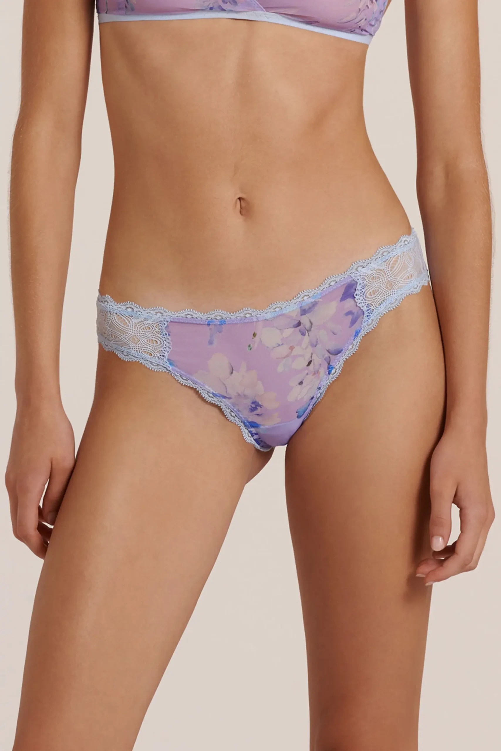 Front view of a model wearing a purple and blue women's brief, posing in a studio